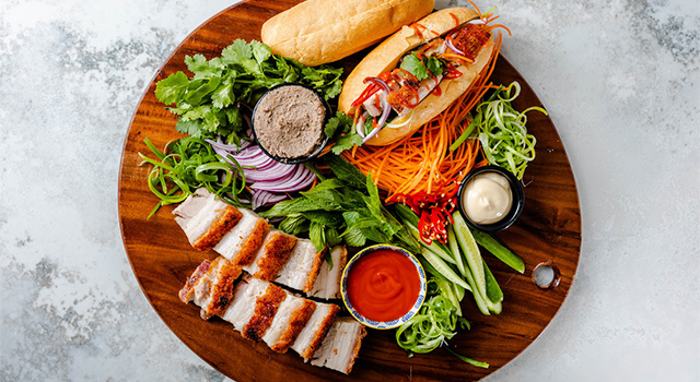 Banh mi with various ingredients on a cutting board