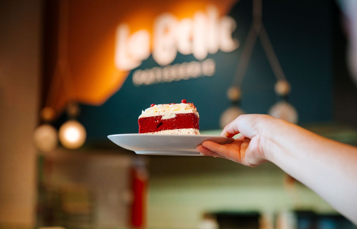 Red Velvet cake in front of La Belle Logo